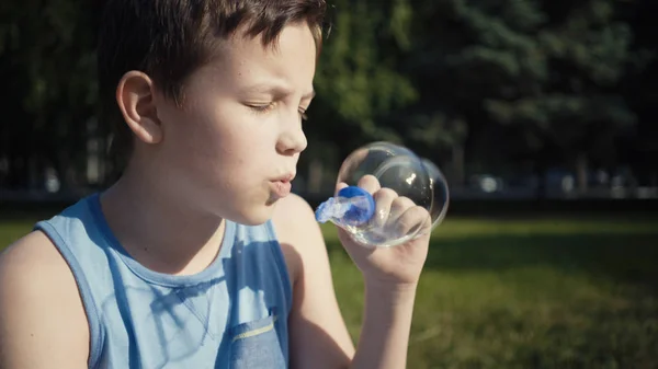 Jongen blazen van zeepbellen buiten zomer. — Stockfoto