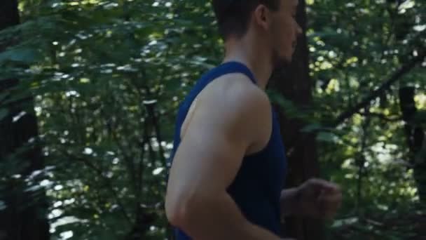 Joven se dedica a correr al aire libre en el bosque . — Vídeo de stock