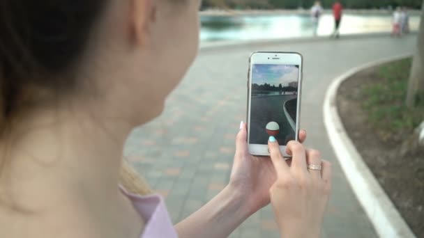 Самара, Россия - 11 июля 2018 года: женщина, играющая в покемон, идет на его iphone. Pokemon Go многопользовательская игра с элементами дополненной реальности. Ловля мясного покемона — стоковое видео