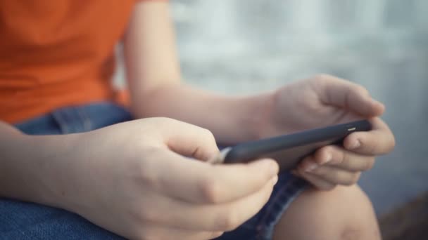 Jonge jongen spelen van videogames op zijn smartphone. — Stockvideo