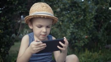 Genç çocuk video oyunları oynarken onun smartphone
