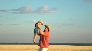 Oğlu ile buğday sahada oynayan genç baba