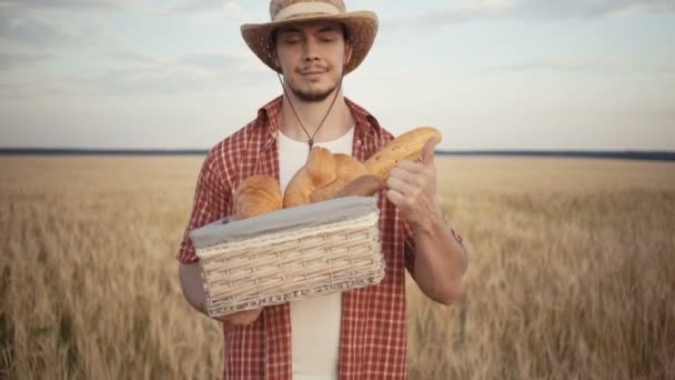 Jonge boer zijn stand langs het tarweveld met brood manden — Stockvideo