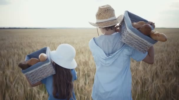 Jungbauern laufen mit Brotkörben über das Weizenfeld — Stockvideo