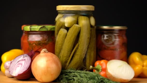 Filmación frascos de vidrio con verduras saladas para el invierno rotado en la mesa . — Vídeos de Stock