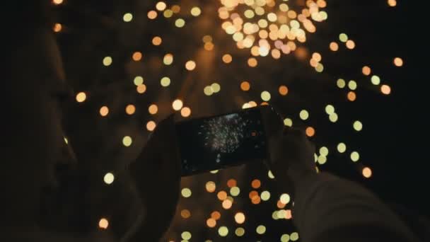 Silueta unei femei care fotografiază focuri de artificii pe cerul nopții . — Videoclip de stoc