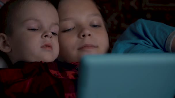 Twee jongens beelden met behulp van tablet pc liggend op de Bank. — Stockvideo