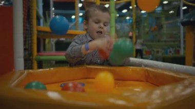 Çocuk üç yaşında Bahçesi havuzunda renkli plastik toplarla oynuyor