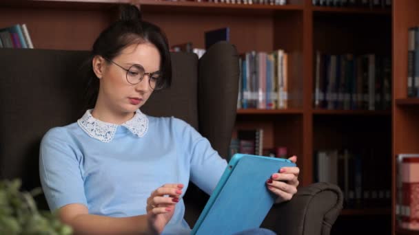 Mladá atraktivní obchodní žena s tabletový počítač v librory kanceláři Knihovnička pozadí — Stock video