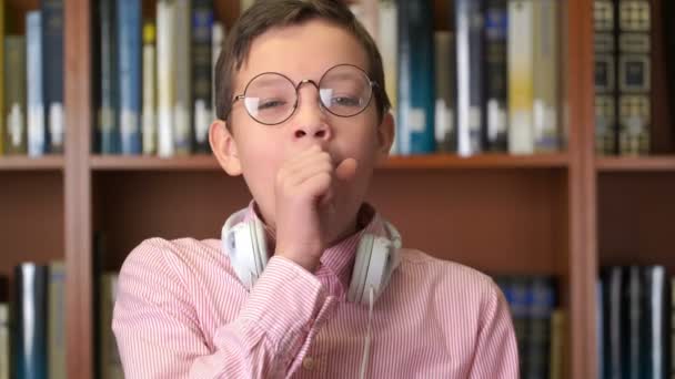 Kütüphane içinde bookshelf yakın duran sevimli yawns okul portre çekim — Stok video