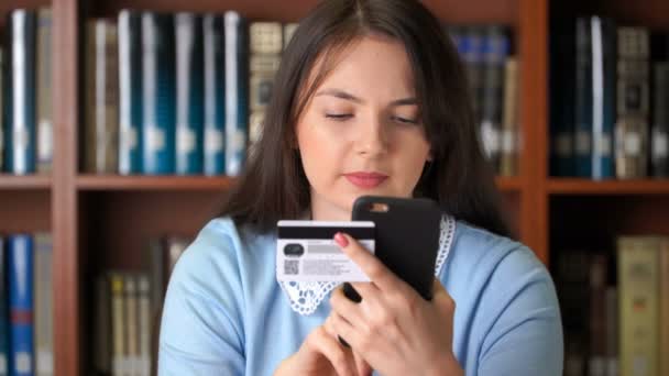 Mooie vrouw online winkelen met gemakkelijk betalen met smartphone en credit card — Stockvideo