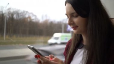 şehirde otobüs ile seyahat ve app akıllı telefon kullanan kadın.
