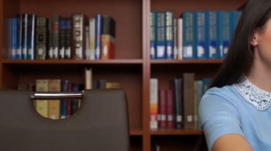 güzel kız kütüphanede veya ofiste bilgisayar tablet kullanma.