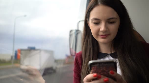 Şehirde otobüs ile seyahat ve app akıllı telefon kullanan kadın. — Stok video