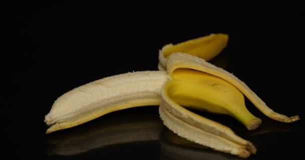 Snijden banaan op zwarte achtergrond — Stockvideo