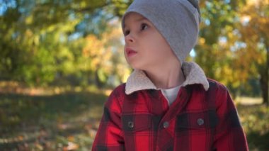 Sonbahar parkta üzgün ya da mutsuz bir çocuk portresi