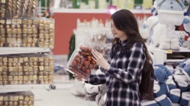 Görüntüleri güzel kadın Noel süsleri satın alma. Kız seçerek Xmas topları. Yeni yıl için hazırlanıyor