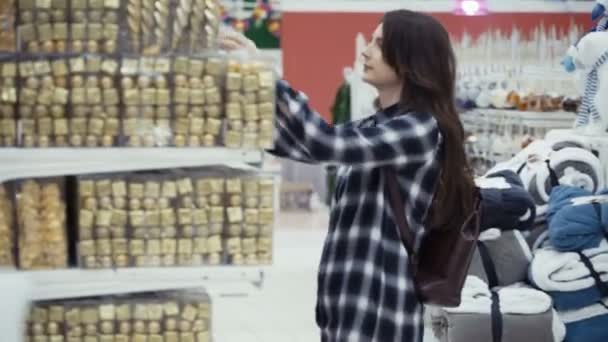 Mujer bonita comprando decoraciones de Navidad — Vídeos de Stock