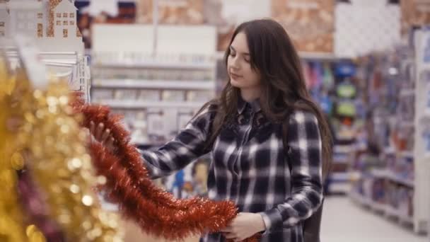 Mujer bonita comprando decoraciones de Navidad — Vídeo de stock