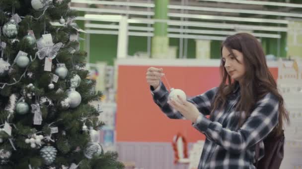 Mujer bonita comprando decoraciones de Navidad — Vídeo de stock