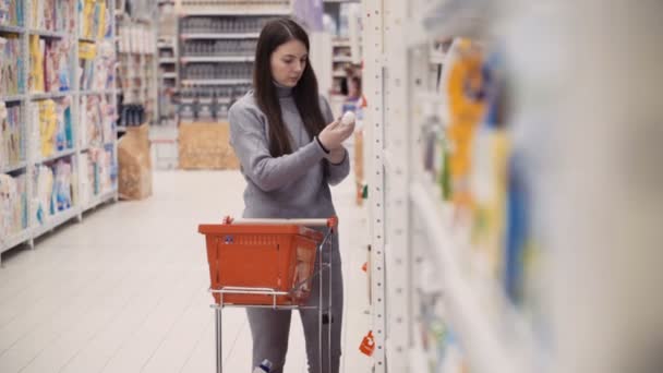 Mujeres jóvenes seleccionando jabón líquido para la casa en el supermercado . — Vídeos de Stock