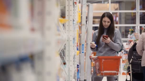 Mulheres jovens comprando produtos de cuidados com o corpo no supermercado . — Vídeo de Stock