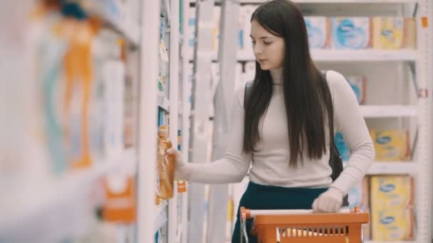 Genç kadın deterjanlar, süpermarket evinde için seçme — Stok video