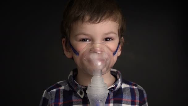 Μήκος σε πόδηα εισπνοή μέσω της συσκευής εισπνοής μάσκα νεαρό αγόρι — Αρχείο Βίντεο