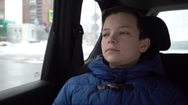 Зимой подросток выглядывает из окна машины — стоковое видео