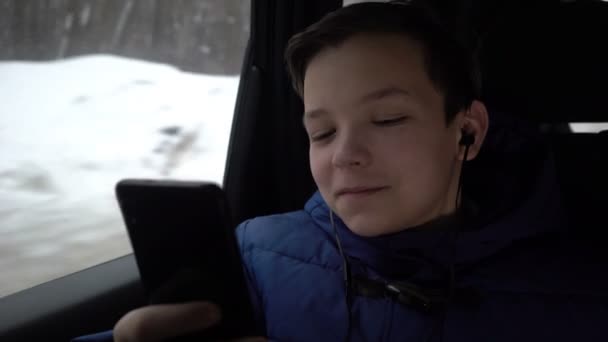 Мальчик с помощью смартфона во время поездки на такси в город — стоковое видео
