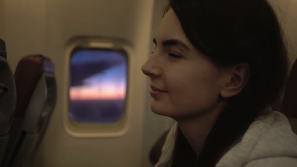 Portret shot van jonge vrouw zittend op de zetel van een vliegtuig. — Stockvideo