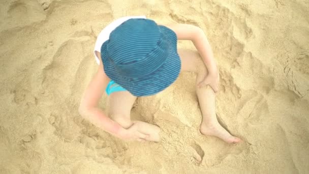 Χαριτωμένο αγόρι παίζει στην άμμο στην τροπική παραλία το καλοκαίρι. — Αρχείο Βίντεο