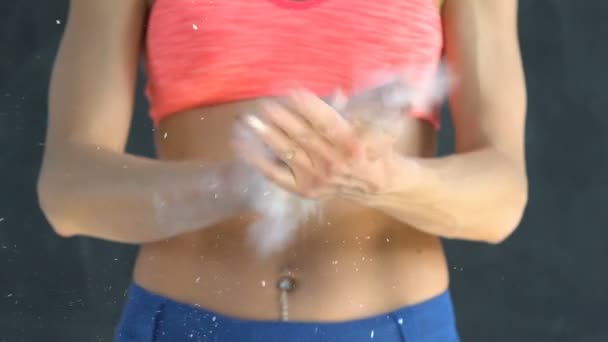 Mujer musculosa aplaudiendo de la mano con talco en polvo en un gimnasio . — Vídeo de stock