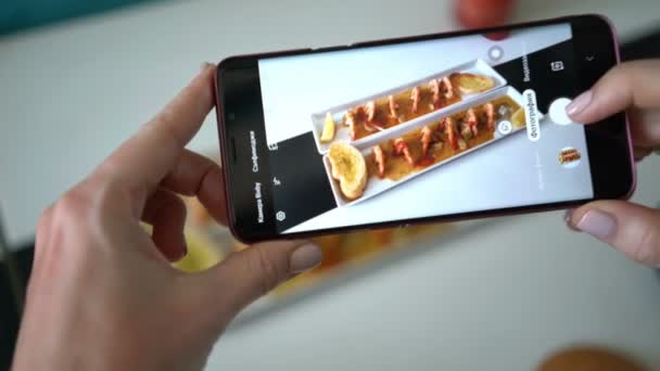 Mädchen fotografiert am Telefon ein Gericht mit Garnelen. — Stockvideo