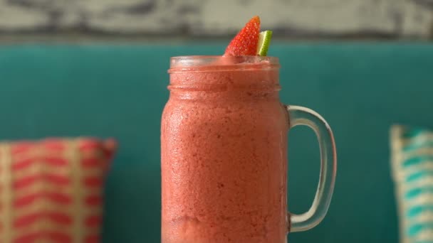 Frischer tropischer Bio-Erdbeer-Smoothie rotiert auf dem Tisch. — Stockvideo