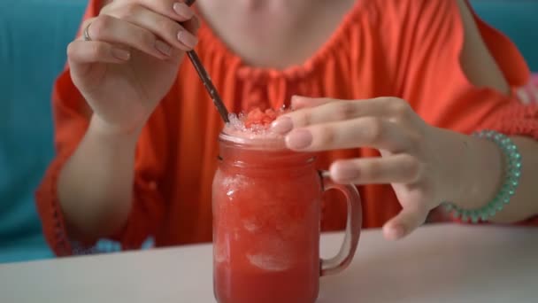 Wanita cantik muda minum semangka smoothie segar tropis goyang dengan es . — Stok Video