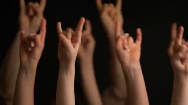 Raising hands with goat gesture or rock sign on black background. — Stock Video