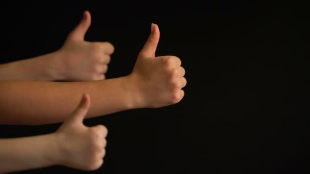 Raising hands with thumbs up on black background. — Stock Video