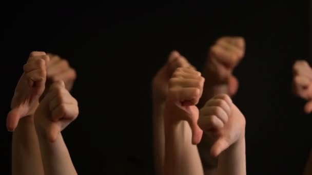 Raising hands with thumbs down on black background. — Stock Video