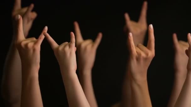 Raising hands with goat gesture or rock sign on black background. — Stock Video