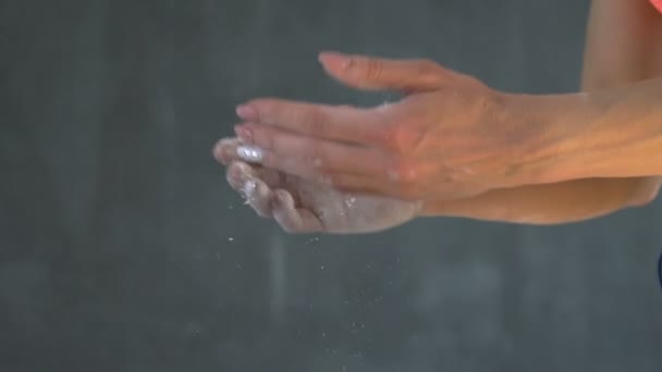 Femme musculaire applaudissant les mains avec de la poudre de talc dans un gymnase . — Video