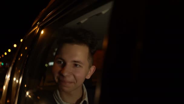 Retrato de jovem adolescente bonito viajando em um carro de táxi com um motorista na cidade noturna. Filmagem 4k — Vídeo de Stock
