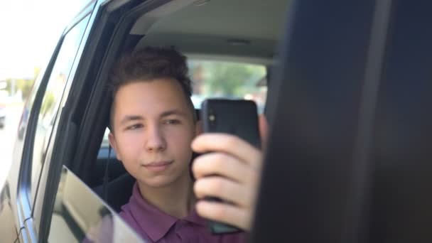 Tonåring gör en selfie i baksätet av en taxi — Stockvideo