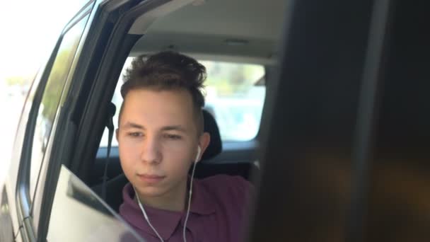 Tonåringen lyssnar på musik i bilen — Stockvideo