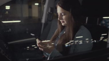 Kadın otoparktaki arabada otururken telefonuna başvurmuş.
