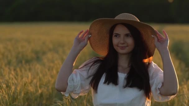 Молодая девушка идет в замедленной съемке по пшеничному полю . — стоковое видео