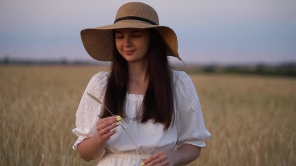 Chica joven con sombrero de paja en el campo de trigo — Vídeo de stock