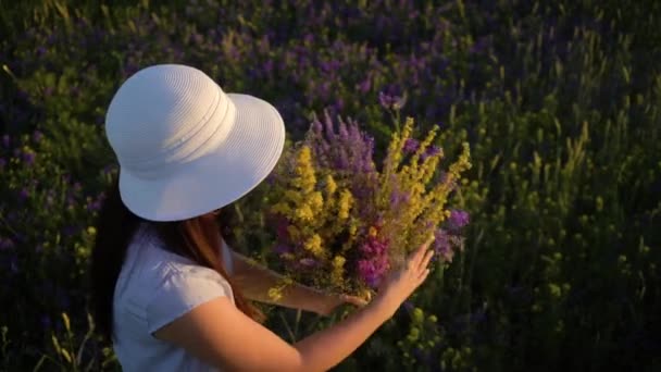 Mladá žena Procházka s Bouketami polní květiny. — Stock video