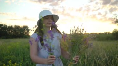 Tarla Çiçeklerinden Buket ile Yürüyen Genç Kadın.