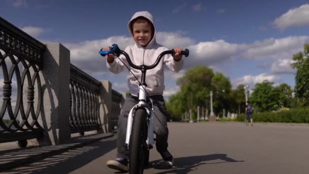 Bonito 3 - 4 anos menino criança aprendendo a andar de bicicleta equilíbrio primeira corrida . — Vídeo de Stock